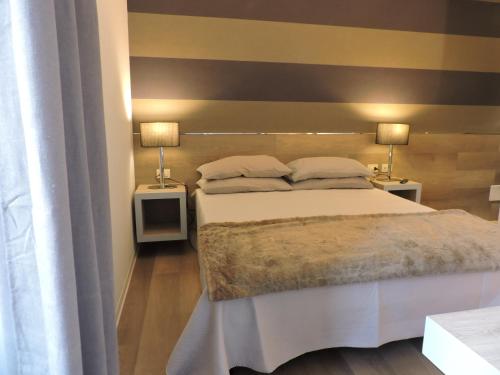 ローマにあるsan cosimato suiteのベッドルーム1室(ベッド1台、ランプ2つ、テーブル2台付)