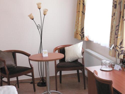 a table and two chairs and a table with a lamp at Hotel Hubertus Hamacher in Willich
