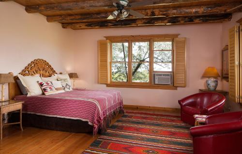 a bedroom with a bed and a chair and a window at Blue Lake Ranch in Hesperus