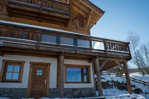 a house with a balcony on top of it in the snow at Les Adrets in Gérardmer