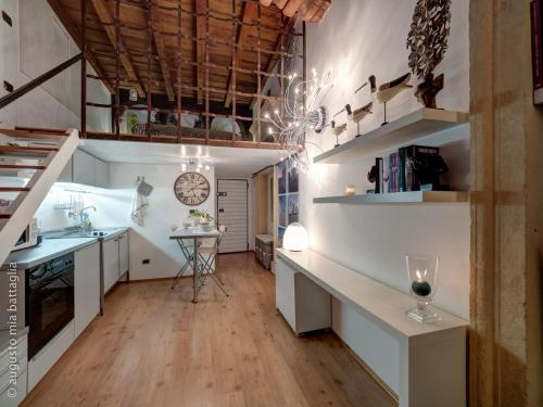Casa Archi - Balcone sul Fiume في فيرونا: مطبخ كبير مع دواليب بيضاء وطاولة