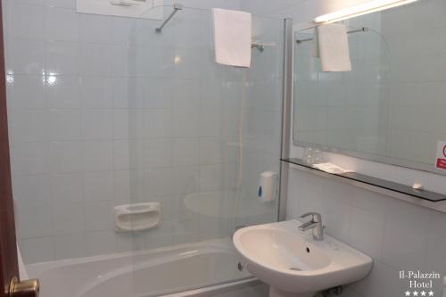 a white bathroom with a sink and a shower at Il Palazzin Hotel in St Paul's Bay