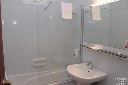 bagno bianco con lavandino e doccia di Il Palazzin Hotel a San Pawl il-Baħar