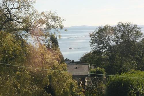 a house on a hill with a view of the water at Nythfa Guest House in Saundersfoot