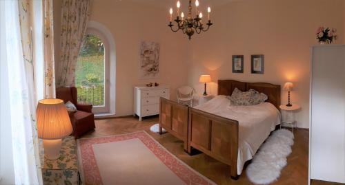 a bedroom with a bed and a chair and a window at Villa Eisenwerk in Wilhelmsburg