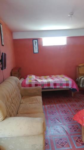 a living room with a couch and a bed at Hostal Puerto Alegre in Copacabana