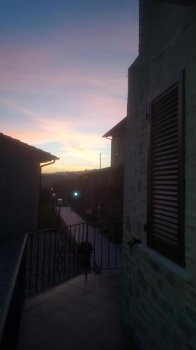 a person standing on a balcony watching the sunset at Agriturismo Villalta in Ponte Felcino