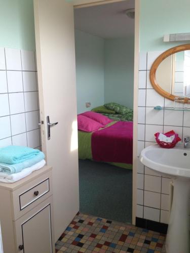 une salle de bain avec un lavabo et un lit dans l'établissement Bel Air, à Marville