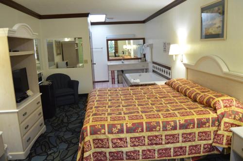 a hotel room with a bed and a bathroom at Economy Inn Cuyahoga Falls in Cuyahoga Falls
