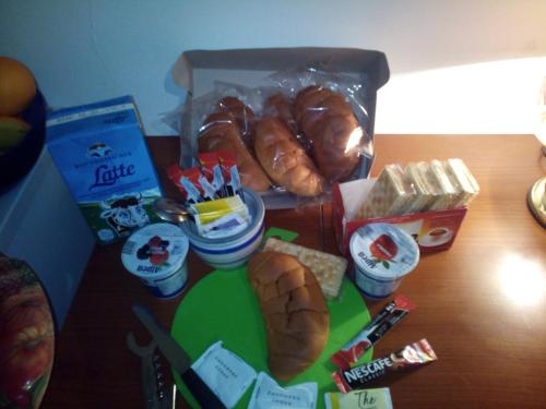 a table topped with bread and pastries and other snacks at Le Rose di Bi in Rome