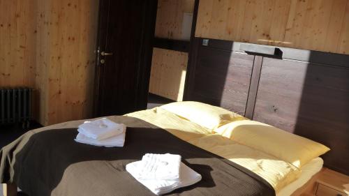 a bed in a room with two towels on it at Krakonošova Dílna "WOODHAUS" in Špindlerův Mlýn