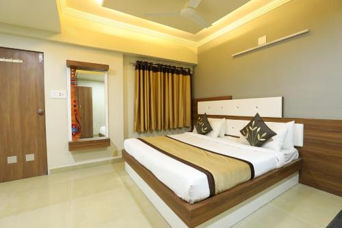 a bedroom with a large bed in a room at Hotel Loyal Residency in Jamnagar