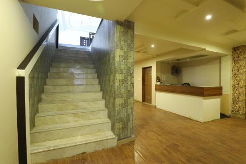 a staircase in a house with a stone wall at Hotel Loyal Residency in Jamnagar