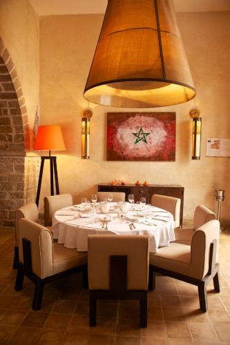 a dining room with a white table and chairs at Madada Mogador in Essaouira