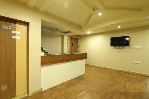 an empty room with a bar and a flat screen tv at Hotel Loyal Residency in Jamnagar
