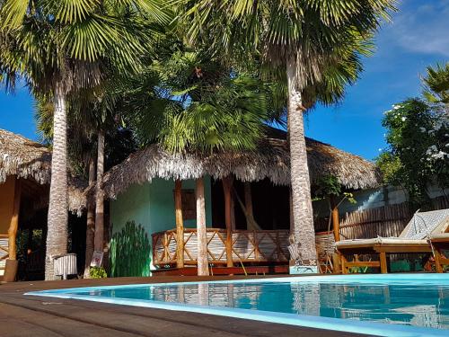 a resort with a swimming pool and palm trees at Terra Patris in Barra Grande