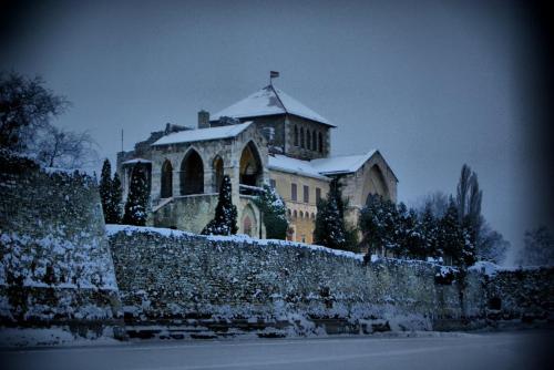 a large building with snow on the top of a wall at Sirály Panzió Tópart in Tata