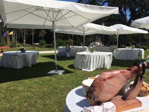 a table with white tables and white umbrellas at Hotel Pazo O Rial in Vilagarcia de Arousa