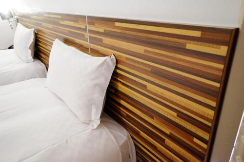 a bedroom with two beds and a wooden wall at Dynasty Hotel in Tainan