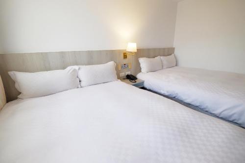 two beds in a hotel room next to each other at Dynasty Hotel in Tainan