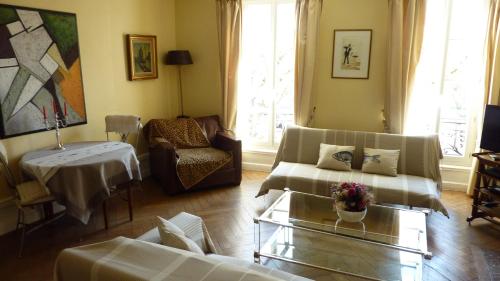 Una sala de estar con dos sofás y una mesa. en Sur Le Vieux Port Appartement Vue Sur Mer, en La Rochelle