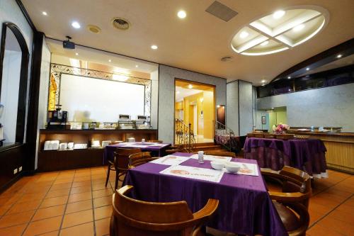 a dining room with tables and chairs in a restaurant at Dynasty Hotel in Tainan