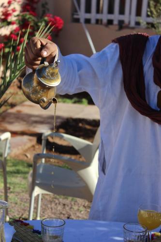 a person is pouring liquid into a tea kettle at Riad Hiba in Foum Zguid
