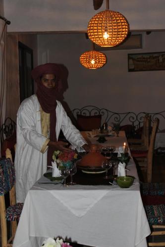 a man standing in front of a table preparing food at Riad Hiba in Foum Zguid