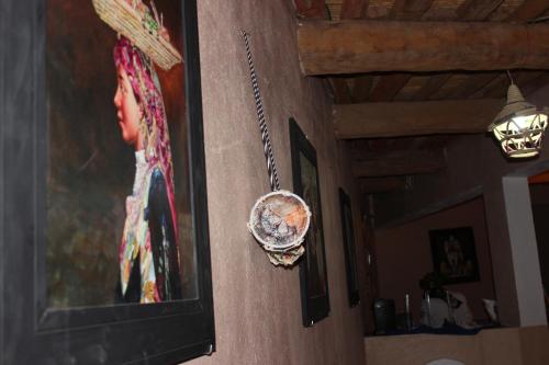 a clock on a wall with a picture of a woman at Riad Hiba in Foum Zguid