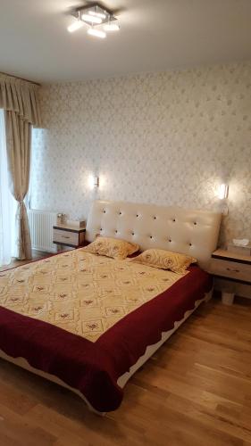 um quarto com uma cama grande e uma grande cabeceira. em Grand View Apartment em Brasov