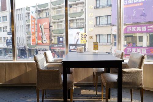 a table and chairs in front of a window at Dynasty Hotel in Tainan