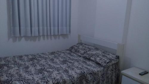 Un dormitorio pequeño con una cama en una habitación. en Edifício NEO 1, en Maceió