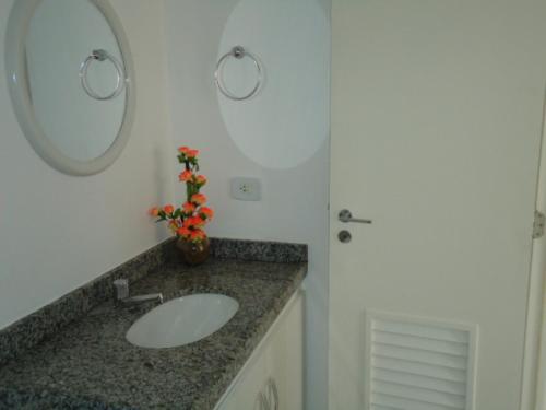 un baño con lavabo y espejo en Edifício NEO 1, en Maceió