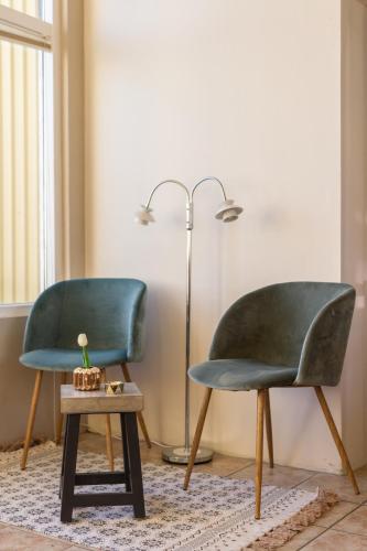 two chairs and a table in a room with a lamp at Finna Hótel in Hólmavík