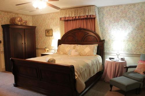 a bedroom with a large bed and a chair at Jailer's Inn in Bardstown