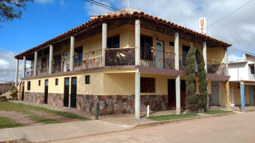 a yellow building with a balcony on a street at Hotel Posada El Camino in Chignahuapan