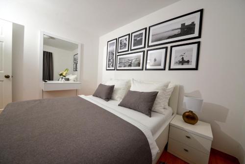 sypialnia z dużym łóżkiem z obrazami na ścianie w obiekcie Sunset Deluxe Villa w mieście Vir