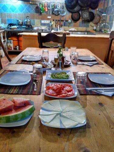 a wooden table with plates of food on it at Casa Rural Ahoraya in El Colmenar