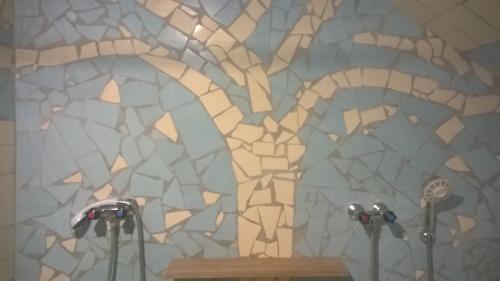 baño con una pared de mosaico con 2 micrófonos en Penzion Lipůvka, en Lipová-lázně