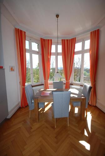 a dining room with orange curtains and a table and chairs at Appartements in zentraler Lage in Tübingen