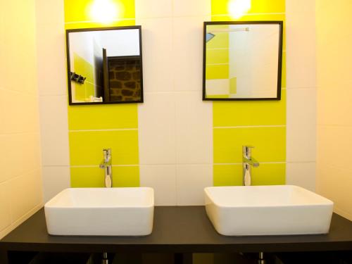 a bathroom with two sinks and two mirrors at Le Crochet de Pervenche in Recoules-Prévinquières