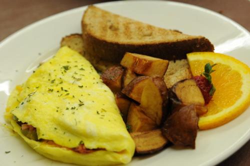 um prato de pequeno-almoço com ovos, batatas e torradas em Acorn Hill Lodge and Spa em Lynchburg