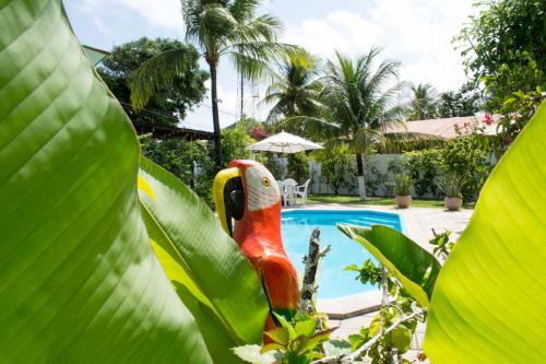 a statue in a leaf next to a swimming pool at Condomínio Oasis das Flores in Porto De Galinhas