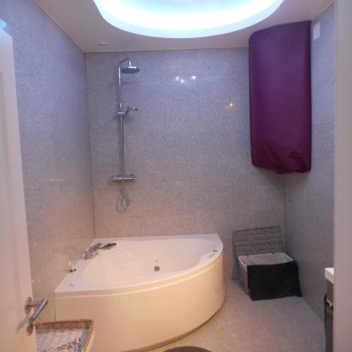 La salle de bains est pourvue d'une baignoire et d'une douche au plafond. dans l'établissement Chez Moera -Sur la Route Des Vins - Kaysersberg, à Kaysersberg