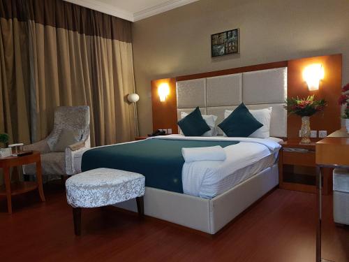 White Moon Al Sadd في الدوحة: غرفة فندقية بسرير كبير وكرسي