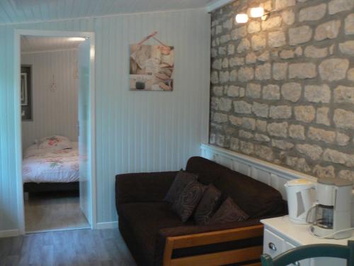 uma sala de estar com um sofá e um quarto em gîte de la maison de l'étang em Sampigny