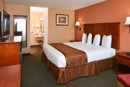 ein Hotelzimmer mit einem großen Bett und einem TV in der Unterkunft Americas Best Value Inn & Suites-East Bakersfield in Bakersfield