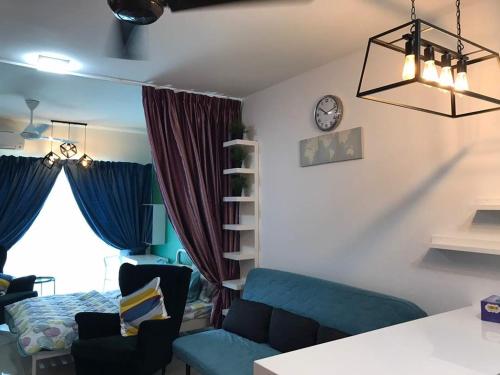 ein Wohnzimmer mit einem blauen Sofa und einer Uhr an der Wand in der Unterkunft Galleria Equine Park in Seri Kembangan