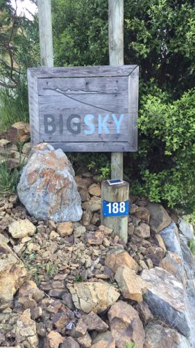 a sign sitting on top of a pile of rocks at Big Sky Nelson Luxury Eco B&B in Nelson