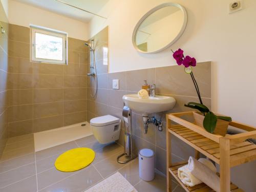 La salle de bains est pourvue d'un lavabo, de toilettes et d'un miroir. dans l'établissement Apartment PAVLA, à Crikvenica